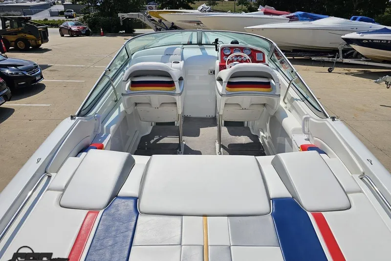 Slide: The Image of 2005 Formula 353 FASTech boat interior with colorful seating and dashboard, parked outdoors. - 42