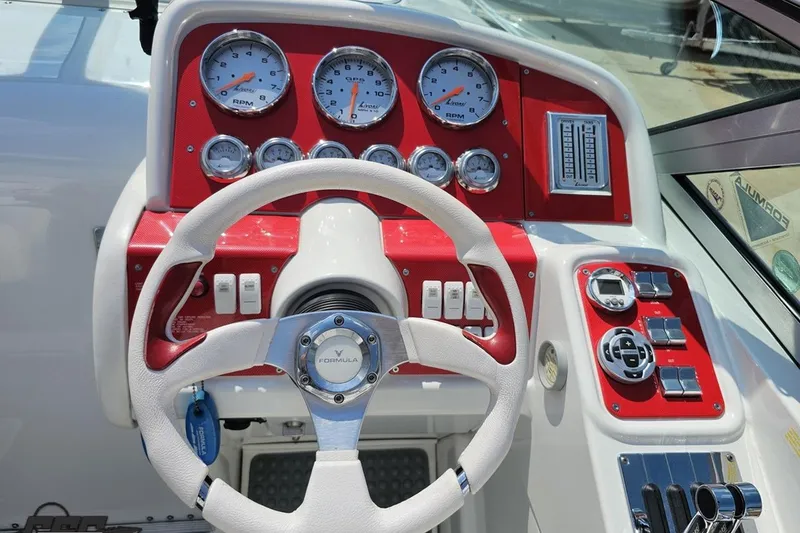 Slide: The Image of 2005 Formula 353 FASTech boat dashboard with red accents and multiple gauges. - 67