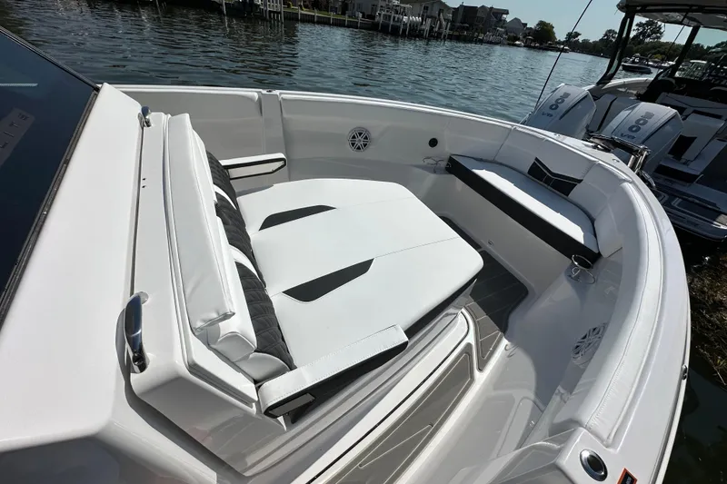 Slide: The Image of 2026 Monterey Elite 25 OB boat interior with sleek seating and modern design on a calm waterfront. - 12