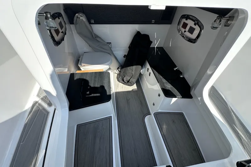 Slide: The Image of Interior of 2026 Monterey Elite 25 OB boat with toilet and storage area. - 15