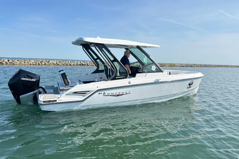 Slide: The Image of 2026 Monterey Elite 25 OB boat cruising on calm water with Mercury outboard engine. - 5