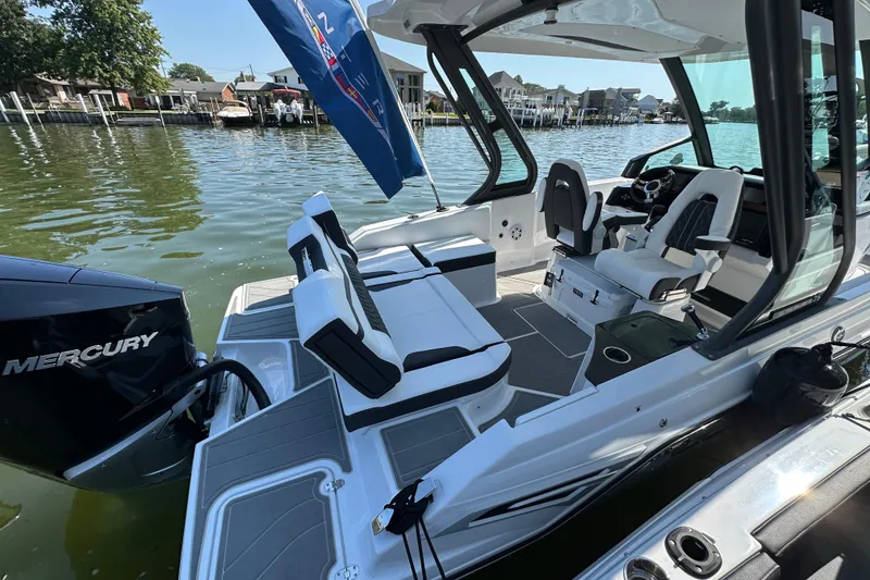 Slide: The Image of 2026 Monterey Elite 25 OB boat interior with seating and Mercury engine on a sunny day. - 6