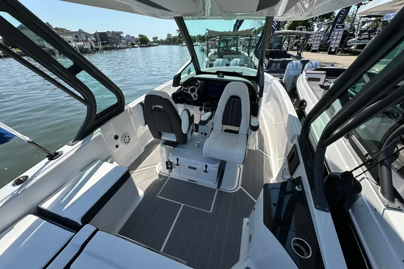 Slide: The Image of 2026 Monterey Elite 25 OB boat interior with sleek seating and modern dashboard on a sunny day. - 7