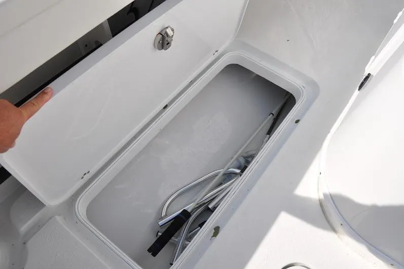 Slide: The Image of Open storage compartment on 2020 Yellowfin 32 Offshore boat, containing metal rods. - 21