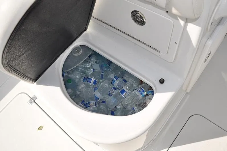 Slide: The Image of Storage compartment on 2020 Yellowfin 32 Offshore boat filled with water bottles. - 23