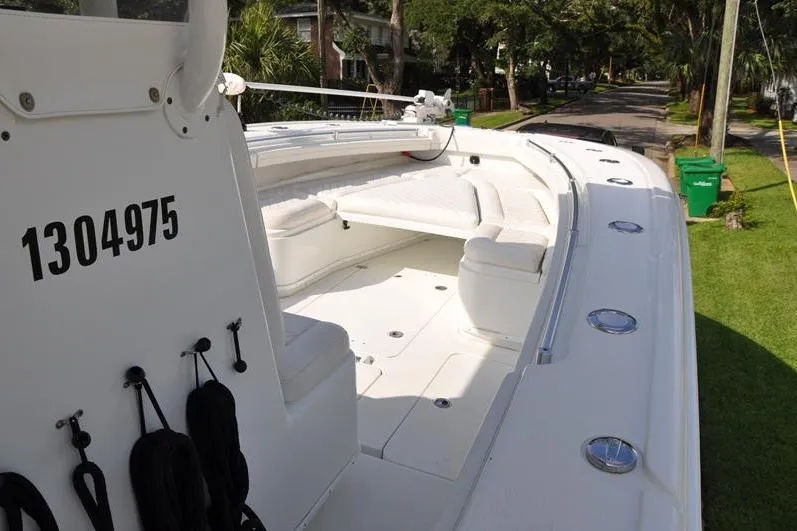 Slide: The Image of 2020 Yellowfin 32 Offshore boat with white seating, docked on a grassy roadside. - 36