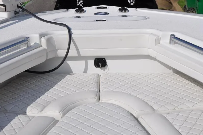 Slide: The Image of 2020 Yellowfin 32 Offshore boat interior with white cushioned seating and control panel. - 43