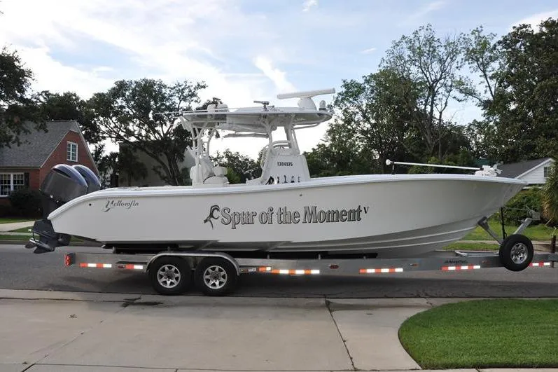 Slide: The Image of 2020 Yellowfin 32 Offshore boat on trailer, named "Spur of the Moment," parked in residential area. - 5