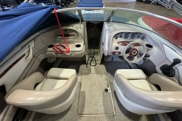 Slide: The Image of 2003 Sea Ray 220 Bow Rider interior with beige seating and dashboard controls. - 5