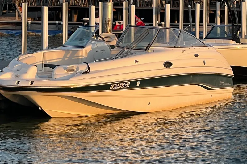 The Image of 2001 Chaparral Sunesta 233 boat docked at marina, reflecting golden sunlight on water. - 1