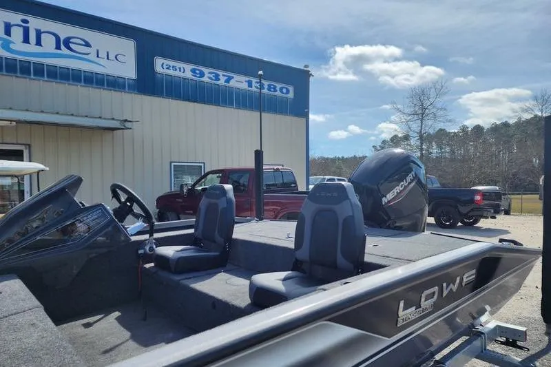Slide: The Image of 2023 Lowe Stinger 178 boat outside a marine dealership under a clear sky. - 3