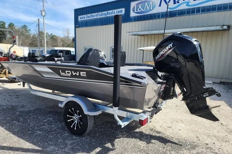 Slide: The Image of 2023 Lowe Stinger 178 boat with Mercury engine on trailer, parked outside dealership. - 6