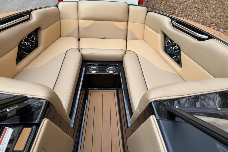 Slide: The Image of 2022 Moomba Mojo boat interior with beige seating, cup holders, and speakers. - 27