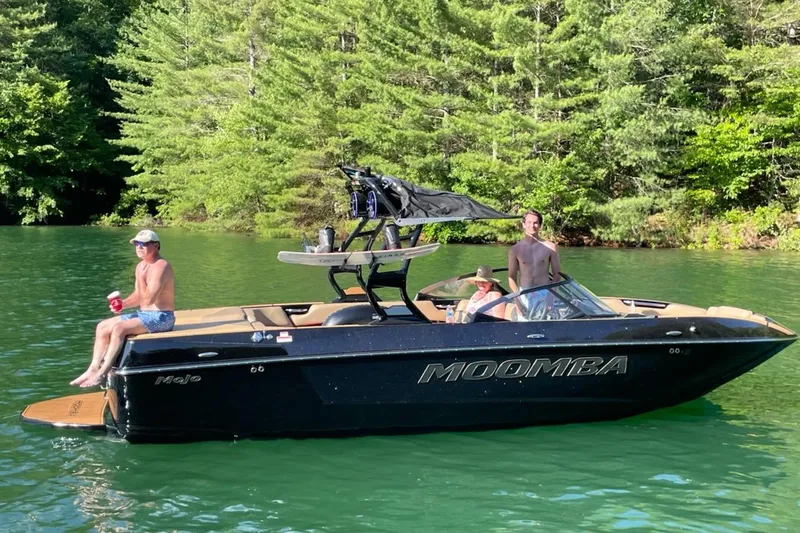 Slide: The Image of 2022 Moomba Mojo boat covered at a dock, surrounded by water and other boats. - 3