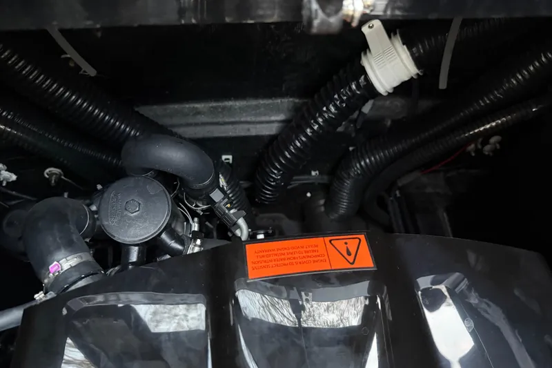 Slide: The Image of Engine compartment of a 2022 Moomba Mojo boat, featuring hoses and warning label. - 7