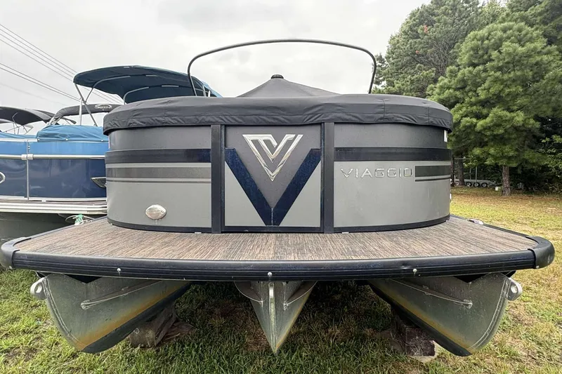 Slide: The Image of 2023 Viaggio D23U pontoon boat with sleek design, docked on grass near trees. - 2