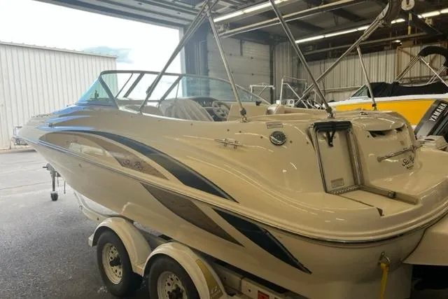 The Image of 1999 Sea Ray 210 Sundeck boat on trailer in indoor storage facility. - 1