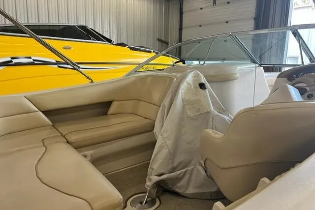 Slide: The Image of 1999 Sea Ray 210 Sundeck interior with beige seating in a storage facility. - 4