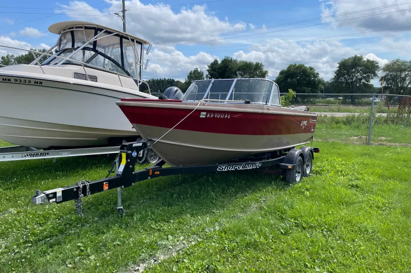 Slide: The Image of 1998 Lund 1800 Fisherman ITS boat, rear view, in showroom with visible propeller and ladder. - 1