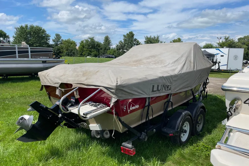 Slide: The Image of Interior of a 1998 Lund 1800 Fisherman ITS boat with red and beige seating. - 15