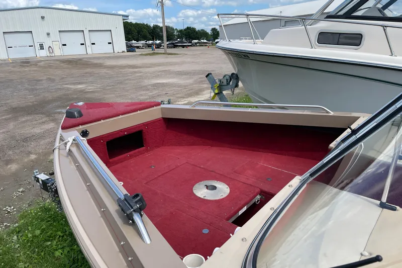 Slide: The Image of 1998 Lund 1800 Fisherman ITS boat interior with red seats and beige cover. - 7