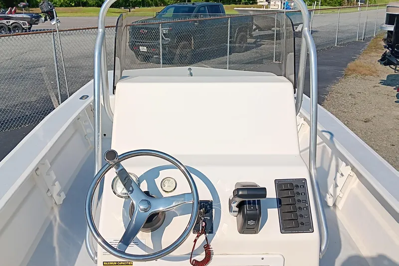 Slide: The Image of 2023 May-Craft 22 Hancock Skiff interior with seating, near a serene lake. - 11