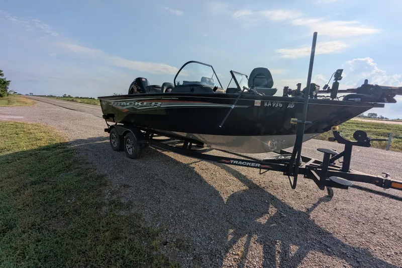 Slide: The Image of 2023 Tracker Targa V-19 Combo Tournament Edition boat on trailer, parked on gravel road. - 10