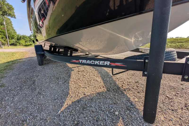 Slide: The Image of 2023 Tracker Targa V-19 Combo Tournament Edition boat on trailer, parked on gravel. - 11