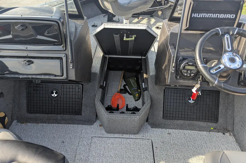 Slide: The Image of 2023 Tracker Targa V-19 Combo Tournament Edition boat interior with steering wheel and storage compartments. - 23