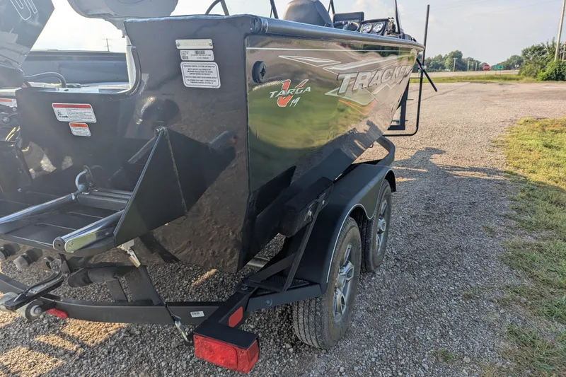 Slide: The Image of 2023 Tracker Targa V-19 Combo Tournament Edition boat on a trailer, parked on gravel. - 7