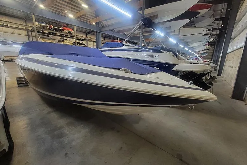 The Image of 1996 Cobalt 252 boat with blue cover in indoor storage facility. - 1