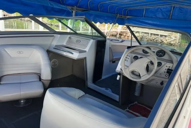 Slide: The Image of Interior of a 1996 Cobalt 220 boat with white seating and blue canopy. - 5