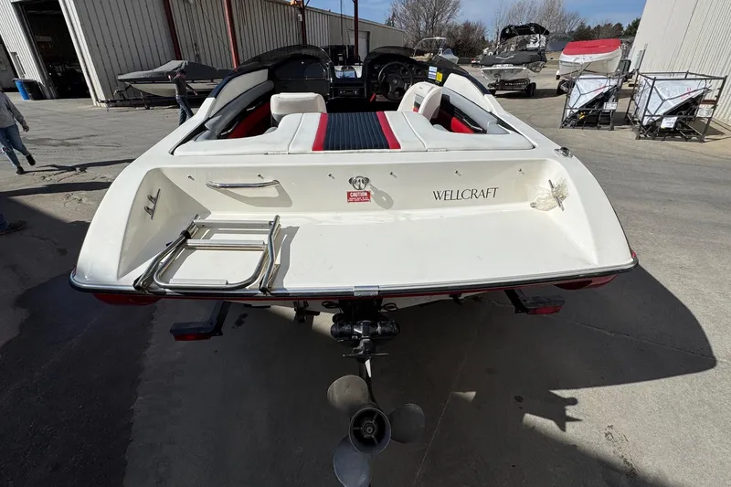 Slide: The Image of 1990 Wellcraft EXCALIBUR boat, rear view with ladder, parked outdoors. - 3
