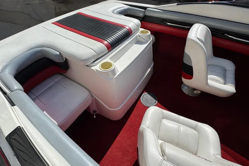 Slide: The Image of 1990 Wellcraft EXCALIBUR boat interior with white and red seating, cup holders, and red carpet. - 5