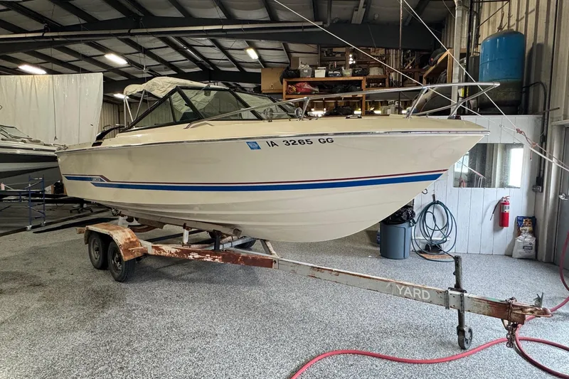 The Image of 1979 Chris-Craft Lancer 22 boat on trailer in indoor storage facility. - 1