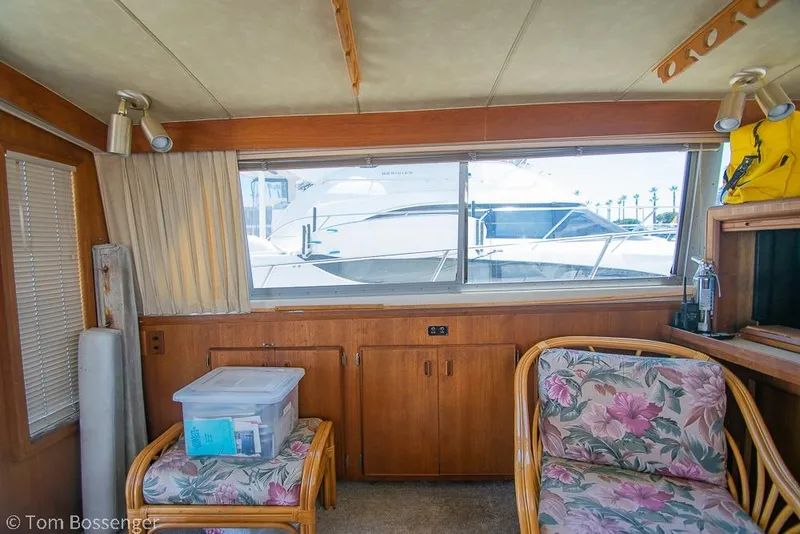 Slide: The Image of Interior of 1986 Bertram 42 Convertible yacht with floral seating and large window view. - 11