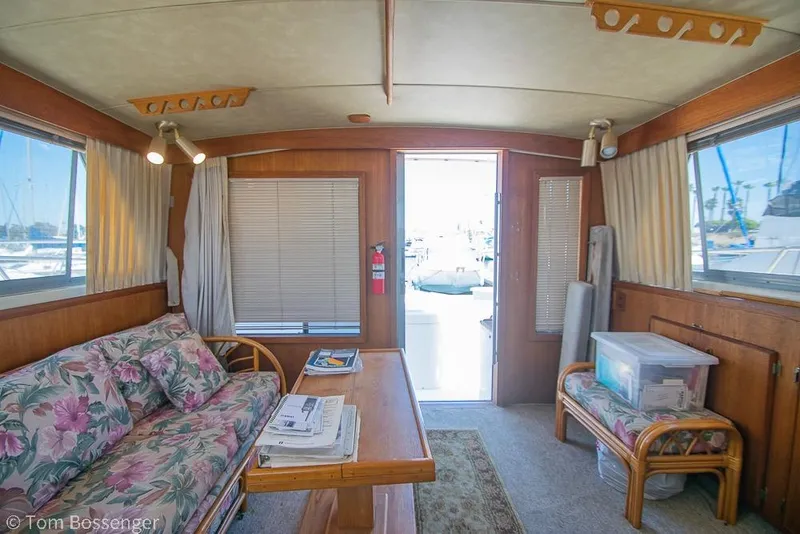 Slide: The Image of Interior of 1986 Bertram 42 Convertible yacht with floral sofa and wooden decor. - 12