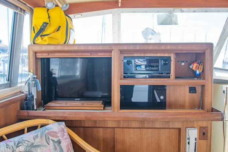 Slide: The Image of 1986 Bertram 42 Convertible interior with TV, stereo, and wooden cabinetry. - 13