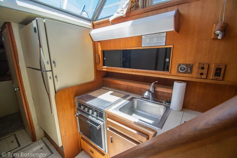 Slide: The Image of 1986 Bertram 42 Convertible yacht kitchen with stove, sink, and refrigerator. - 15