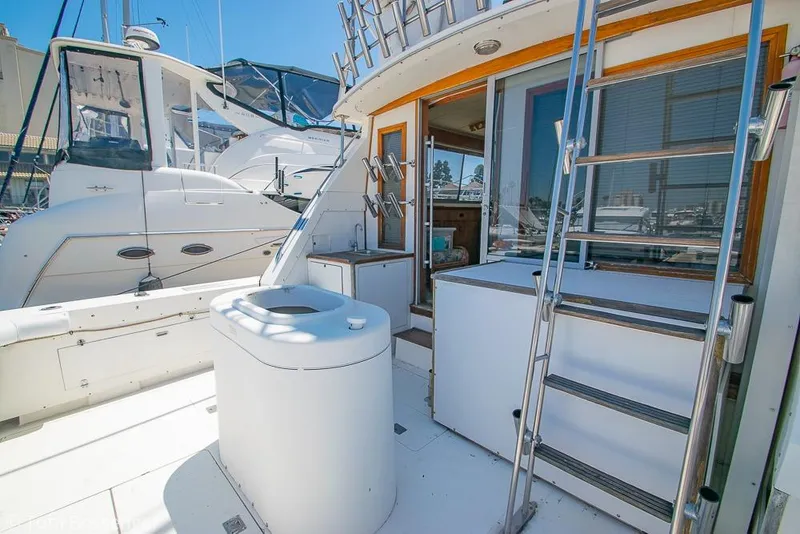 Slide: The Image of 1986 Bertram 42 Convertible yacht deck with ladder and seating area. - 23