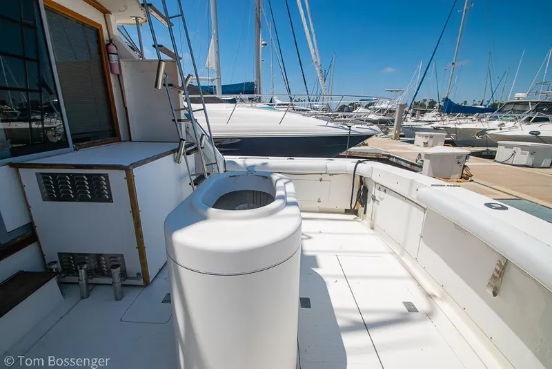 Slide: The Image of 1986 Bertram 42 Convertible yacht deck with marina view, featuring seating and storage. - 25