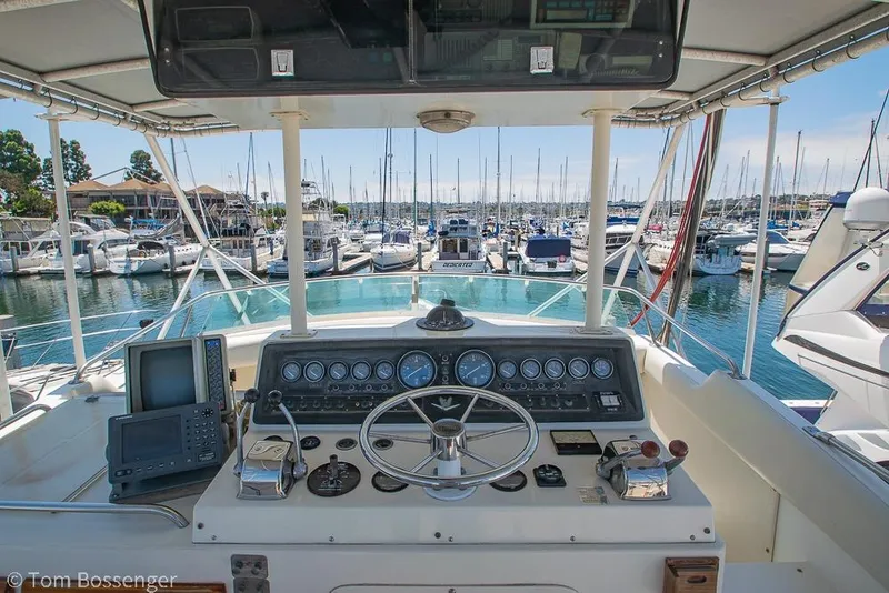 Slide: The Image of Helm of 1986 Bertram 42 Convertible yacht in marina, featuring navigation equipment and steering wheel. - 28