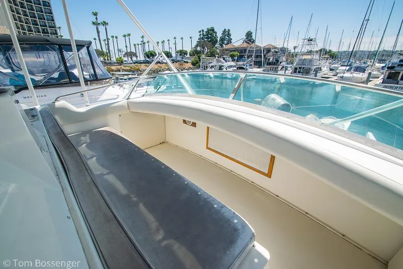 Slide: The Image of 1986 Bertram 42 Convertible yacht interior with marina view, featuring spacious seating area. - 34