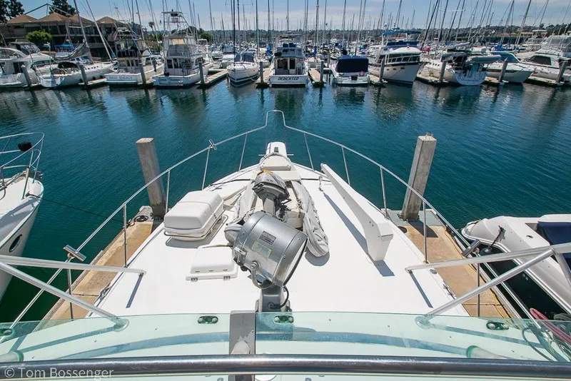 Slide: The Image of 1986 Bertram 42 Convertible yacht docked in a marina, surrounded by other boats. - 35