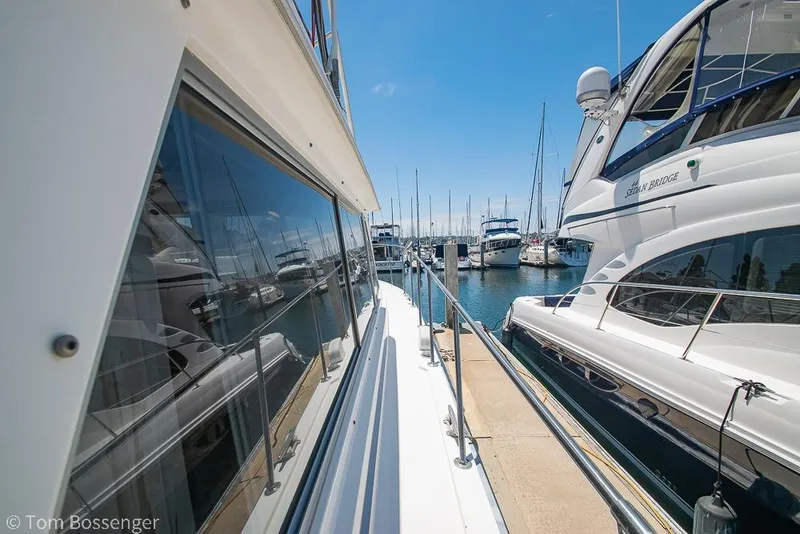 Slide: The Image of 1986 Bertram 42 Convertible yacht docked at marina, reflecting clear blue sky. - 36