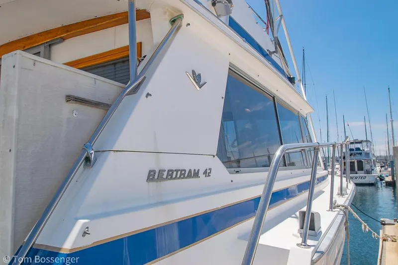 Slide: The Image of 1986 Bertram 42 Convertible yacht docked at marina, side view. - 6