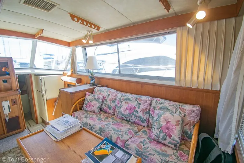Slide: The Image of Interior of 1986 Bertram 42 Convertible yacht with floral sofa and wooden accents. - 8