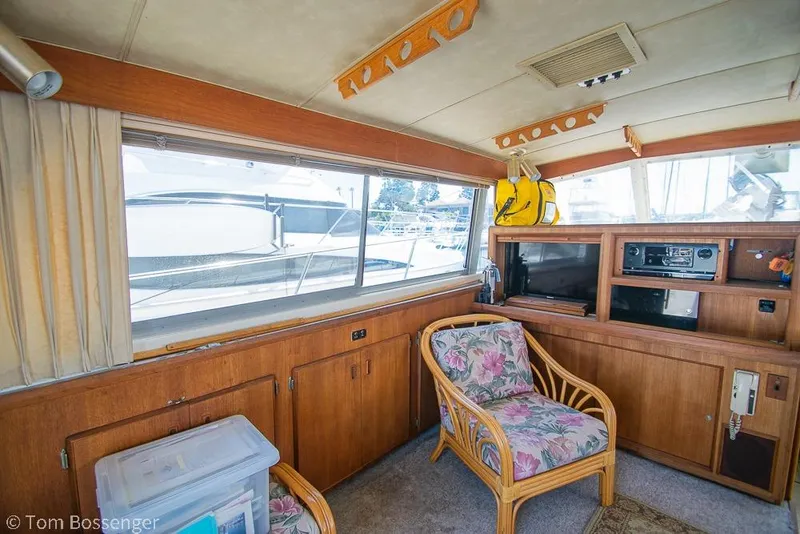 Slide: The Image of Interior of 1986 Bertram 42 Convertible yacht with floral chair and wooden cabinetry. - 9