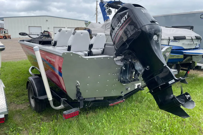 Slide: The Image of 2014 Crestliner 1750 Fish Hawk boat with Mercury outboard motor, parked on grass. - 23