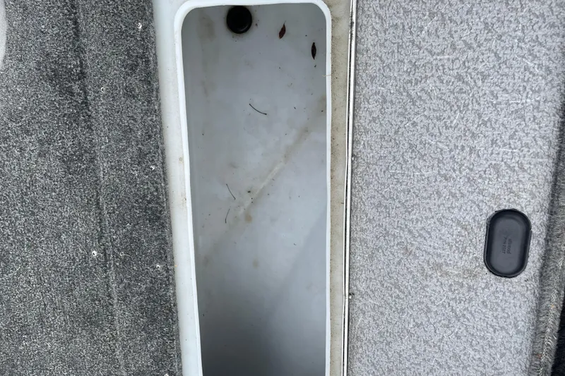 Slide: The Image of 2014 Crestliner 1750 Fish Hawk boat storage compartment with gray carpeted interior. - 35